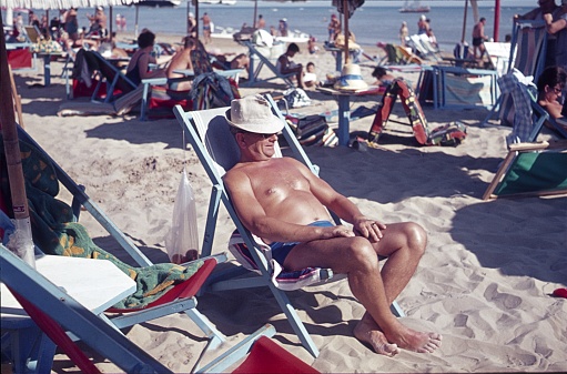Miramare, Veneto, Italy, 1962. Holidaymakers from Central Europe sunbathing in folding chairs on the beach in Miramare. Also: other vacationers.