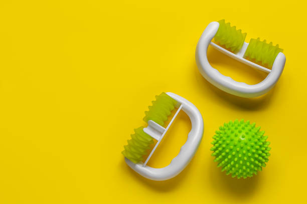 istock body massage ball. manual roller massager. Yellow background. copy space 1980862222