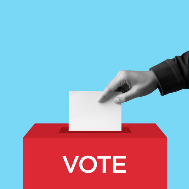 istock Voter hand Holds Envelope In Hand Above Vote Ballot 1980866965