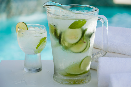 Fresh and cold cucumber water in a pitcher by the pool