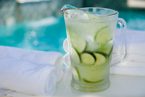 Fresh and cold cucumber water in a pitcher by the pool