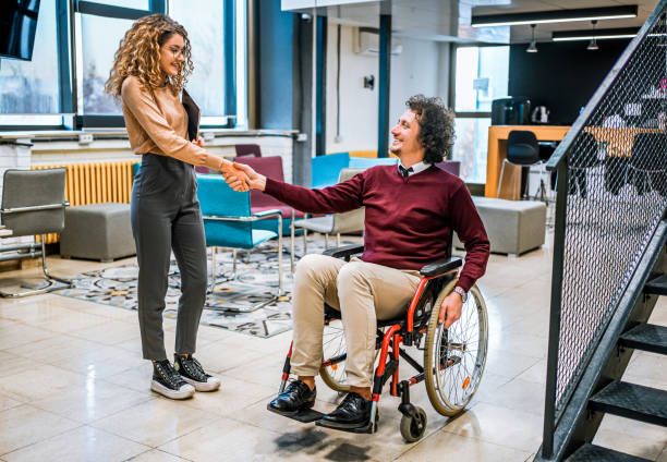 istock Woman shaking hands with her disabled coworker 1980908106