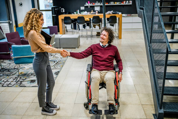 istock Woman shaking hands with her disabled coworker 1980908788
