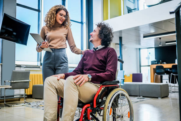 istock Woman talking with her disabled coworker 1980910067