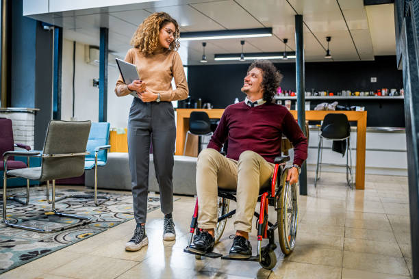 istock Woman talking with her disabled coworker 1980910199