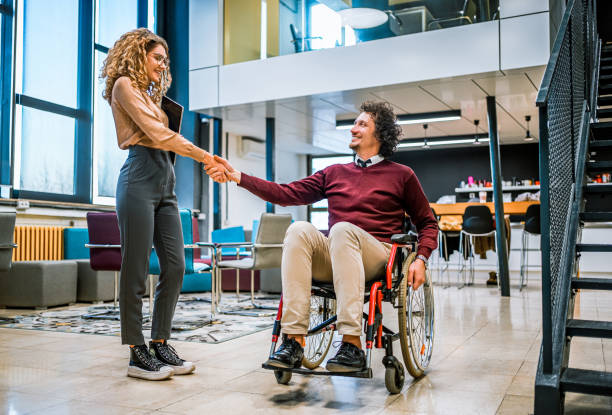 istock Woman shaking hands with her disabled coworker 1980910722