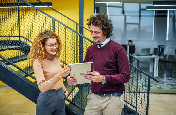 istock Young cheerful business man and woman using tablet 1980912803