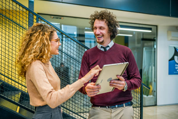 istock Young cheerful business man and woman using tablet 1980919034