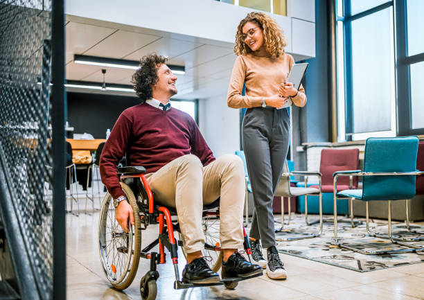 istock Woman talking with her disabled coworker 1980920072