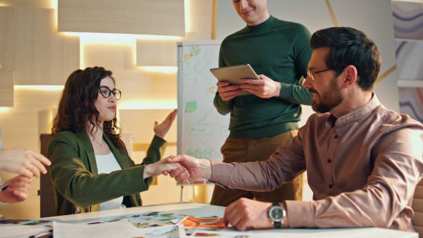 istock Happy team handshaking boardroom. Coworkers rejoicing successful collaboration 1980932120
