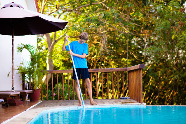 istock Boy cleaning swimming pool. Maintenance, service. 1980934242