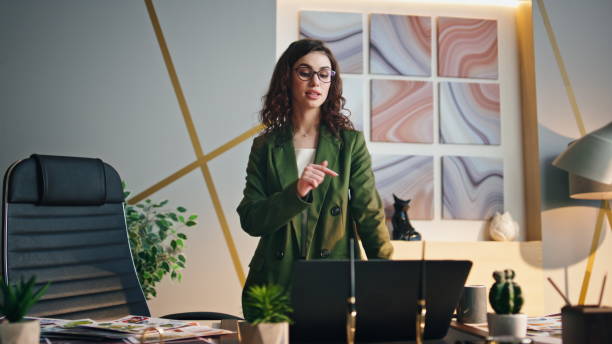 istock Manager talking online presentation looking laptop camera office. Girl speaking 1980935346