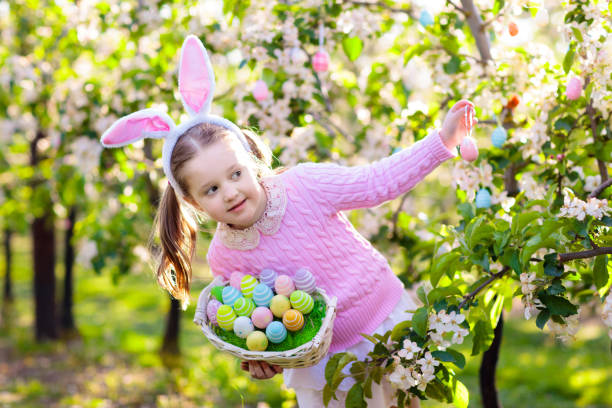 istock Child with bunny ears on garden Easter egg hunt 1980963149