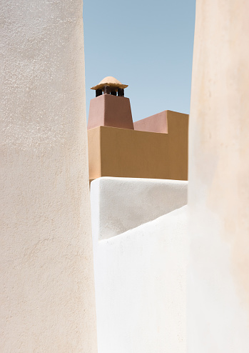 Pastel colored building on the island of Santorini in boho style and typical Cycladic geometric shapes. Greece, Oia