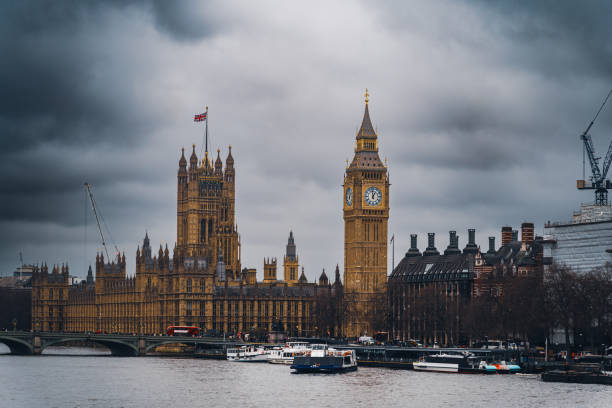 big ben et le palais de westminster avec des nuages sombres et dramatiques se formant au-dessus de londres - british flag big ben london england large photos et images de collection