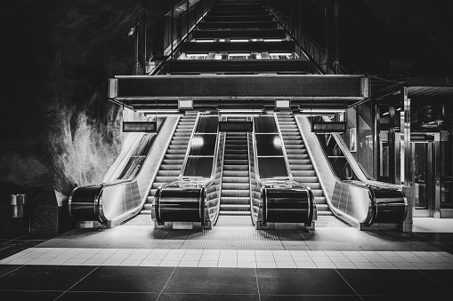 a black and white image of escalators