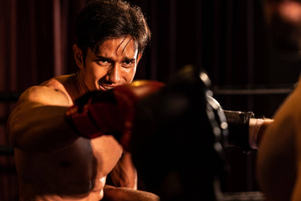 Asian and Caucasian boxer unleash their power in fierce boxing match. boxer with strong muscular body exchanging punch and strike with relentless combat prowess. Impetus