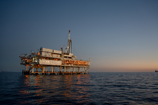 Evening Drone Image Offshore Oil Rig Used for Fracking with Bright Lights