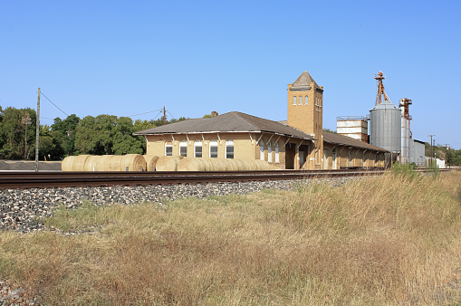 An old train station with hay bales next to it in Weatherford, Texas