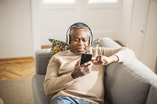 Cheerful mature man having video call, using digital tablet