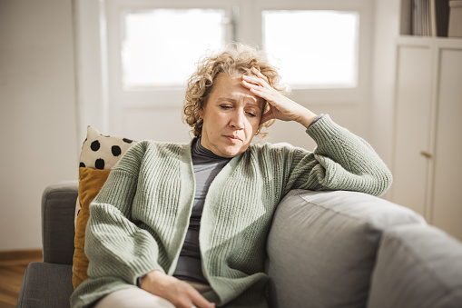 Portrait of mature woman at home. She is stressed and unhappy about something.