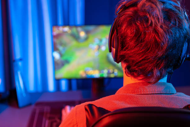 istock Streamer playing fighting Moba, wearing headphone and mic at back side. Gusher. 1981195131