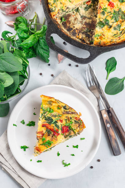 istock Piece of brunch egg frittata with vegetables on plate, vertical, top view 1981226125
