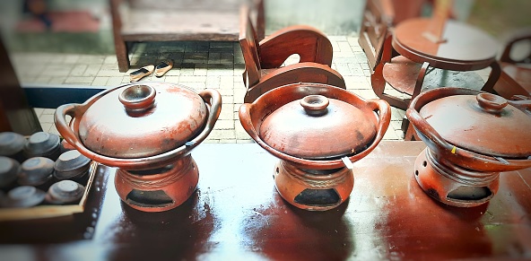 Clay pottery frying pan set. Brazier frying pan for making serabi. Small clay frying pan with stove. Pottery crafts from Indonesia in the form of kitchen utensils.