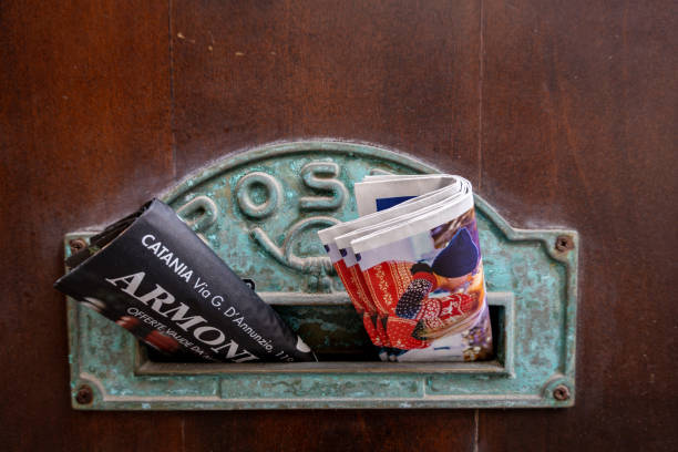 Cefalu, Sicily, Italy Jan 14, 2024 A mailbox on a wooden door with newspapers.