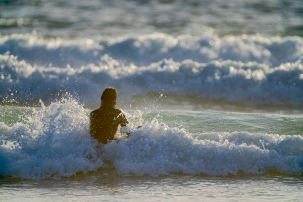 The Pacific Rim National Park on Vancouver Island on April  27, 2023: Young female entering the water for a surfing session at Pacific Rim National Park on Vancouver Island, British Columbia