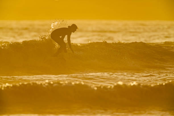 Haleiwa, Hawaii, USA – December 2, 2000: Surfing on the North Shore, female surfer. The North shore of Oahu is famous for big waves in the winter surf season.