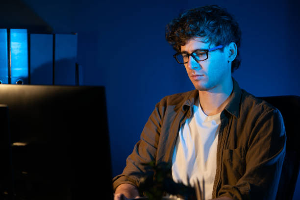 istock Businessman concentrating on pc on project at neon light office. Gusher. 1981302774