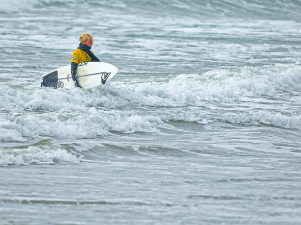 The Pacific Rim National Park on Vancouver Island on April  16, 2023:   Young male exiting the ocean after a surfing session at Pacific Rim National Park on Vancouver Island, British Columbia
