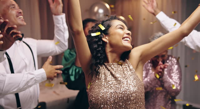 Business people, dancing and new year celebration with confetti at party, happy or excited in night. Men, women and smile with sparkle, gold and silver glitter for cheers at gala, fashion or friends