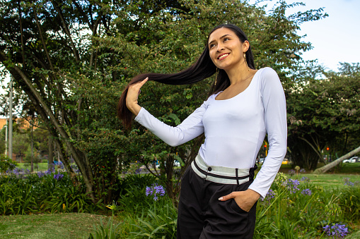 Beautiful young woman posing in a public park