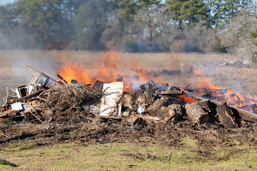 Burning a large trash pile in a pasture