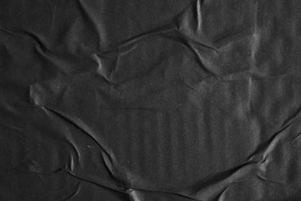 istock Black paper poster glued on a wall texture background 1981685422