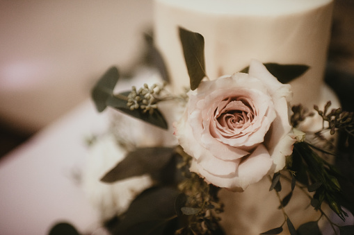 Vanilla wedding cake with roses and greenery