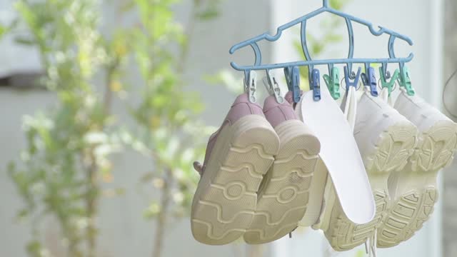 Washed sneakers drying on a hanger