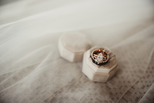 Close up of wedding ring and band with velvet ring box