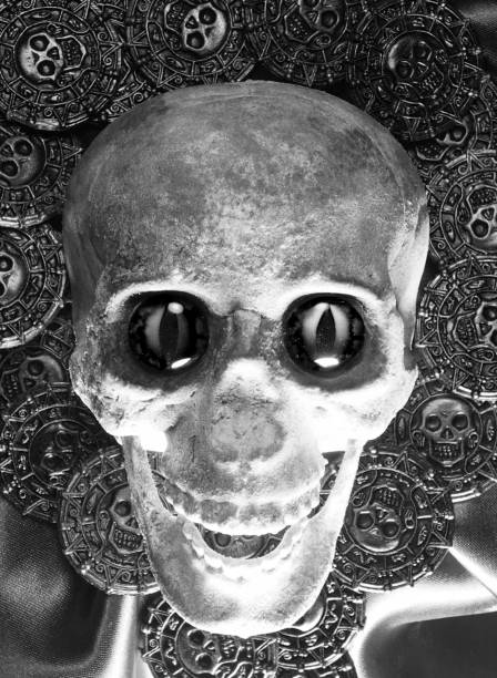 homemade scary skulls with menacing eyes and pirate treasure coins background - bronze rubber plastic metal zdjęcia i obrazy z banku zdjęć