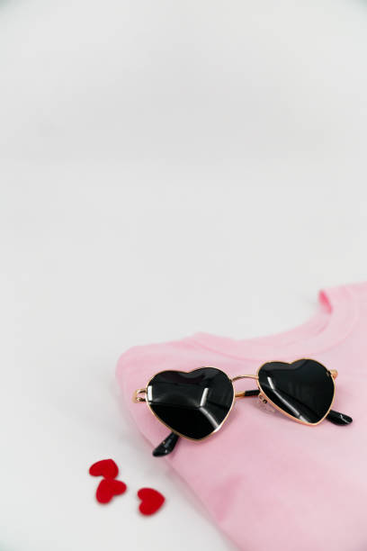 istock Vertical white backdrop with pink shirt and heart sunglasses 1981743721