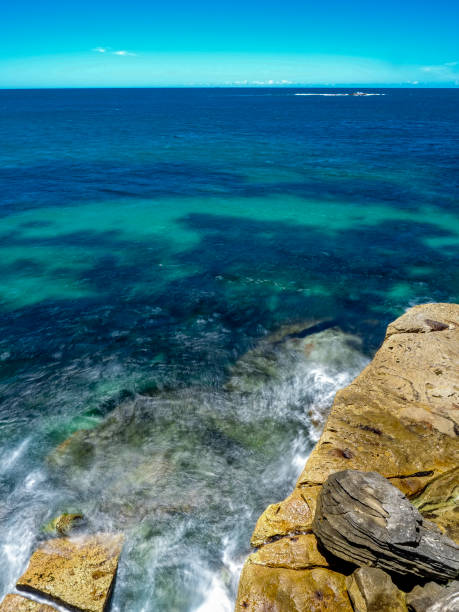 istock Powerful white swirling waves (blurred motion) crashing into coastline rocks 1981806248