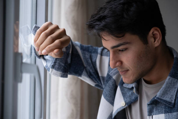 istock Handsome young man looking away from window 1981885789