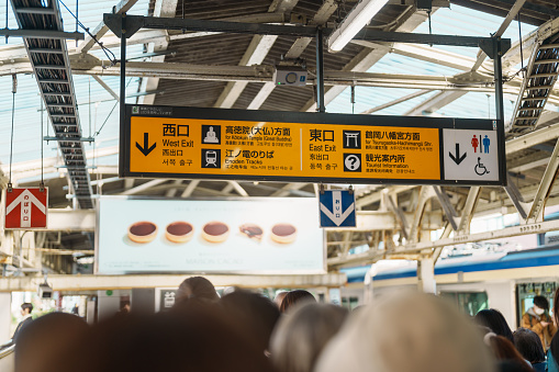 London, UK - July 27 2022: Travellers walk through the main concourse past travel information boards at King's Cross Station