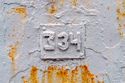 Number 334 made of grey metal elements with traces of rust