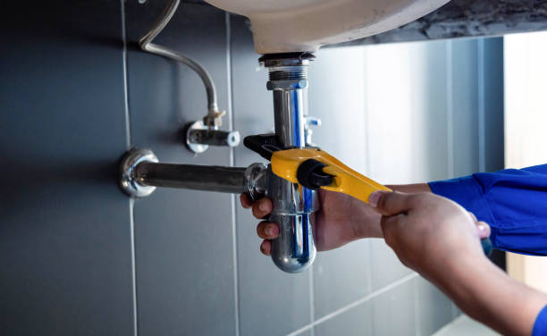 plumber fixing white sink pipe with adjustable wrench. - water pipe home improvement pipe valve foto e immagini stock