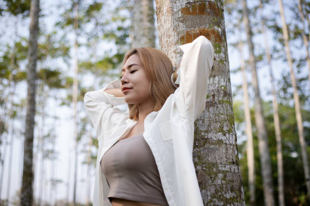 istock Asian woman standing under the tree and closed eyes for relax. 1982004129