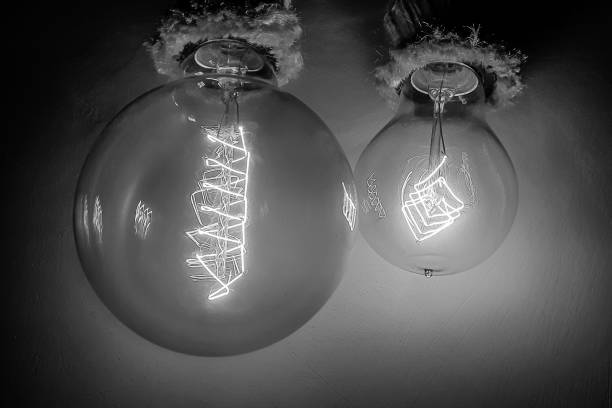 Edison light bulbs with a tungsten spiral in a vacuum close-up next to a concrete wall