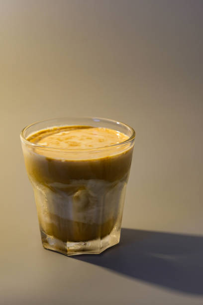 Dirty Coffee style  in a clear coffee cup isolated warm light tone background